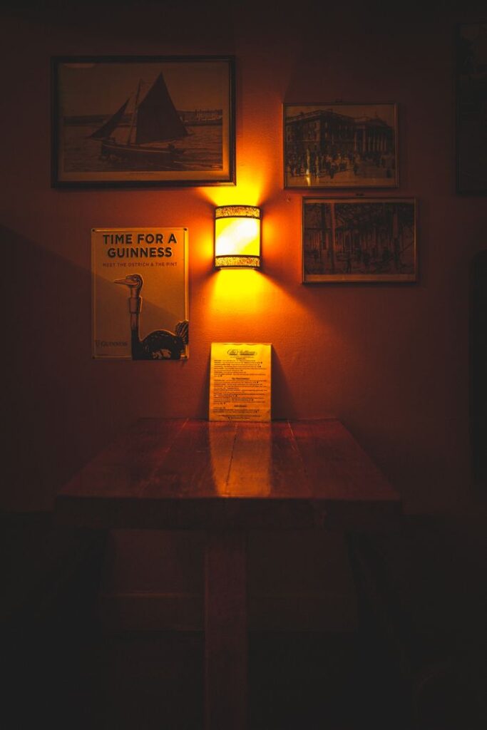 A wooden table in a warmly lit pub corner with vintage frames.