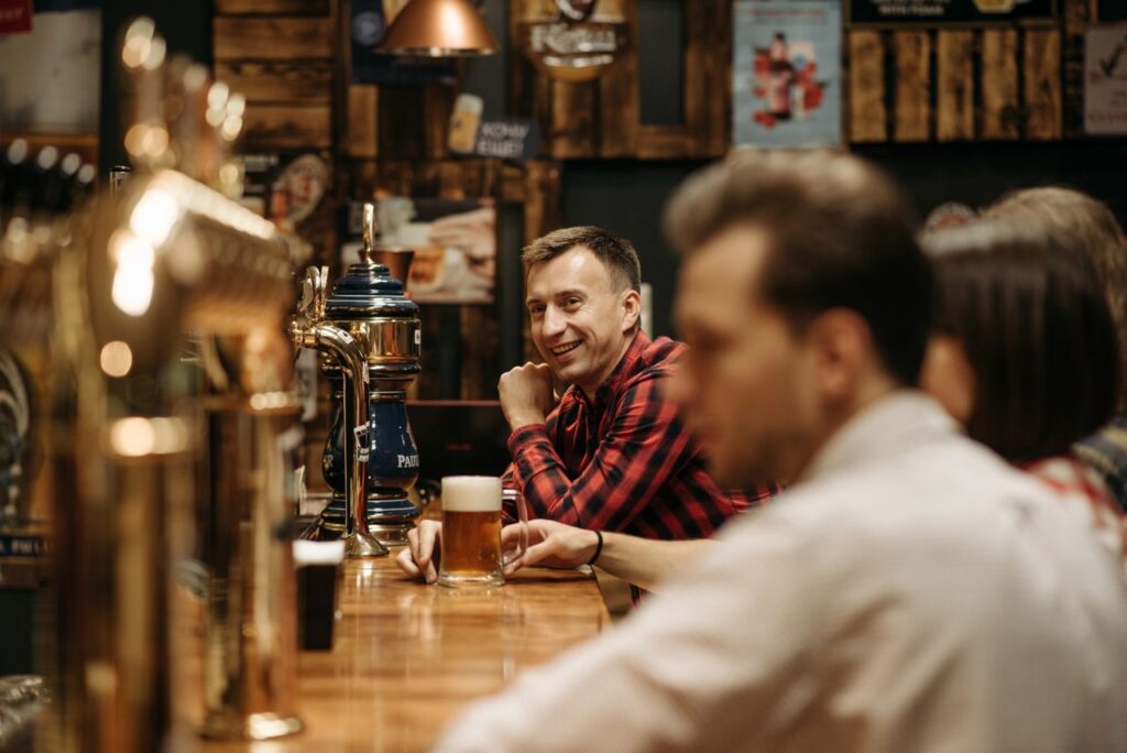 A cheerful group enjoying drinks at a cozy pub bar, capturing leisure and social vibes.